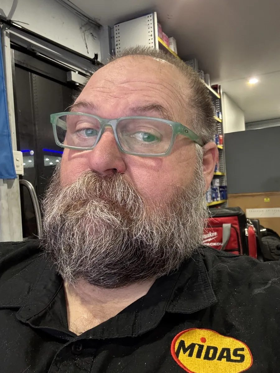 Adam in the workshop, green glasses and a big grey beard